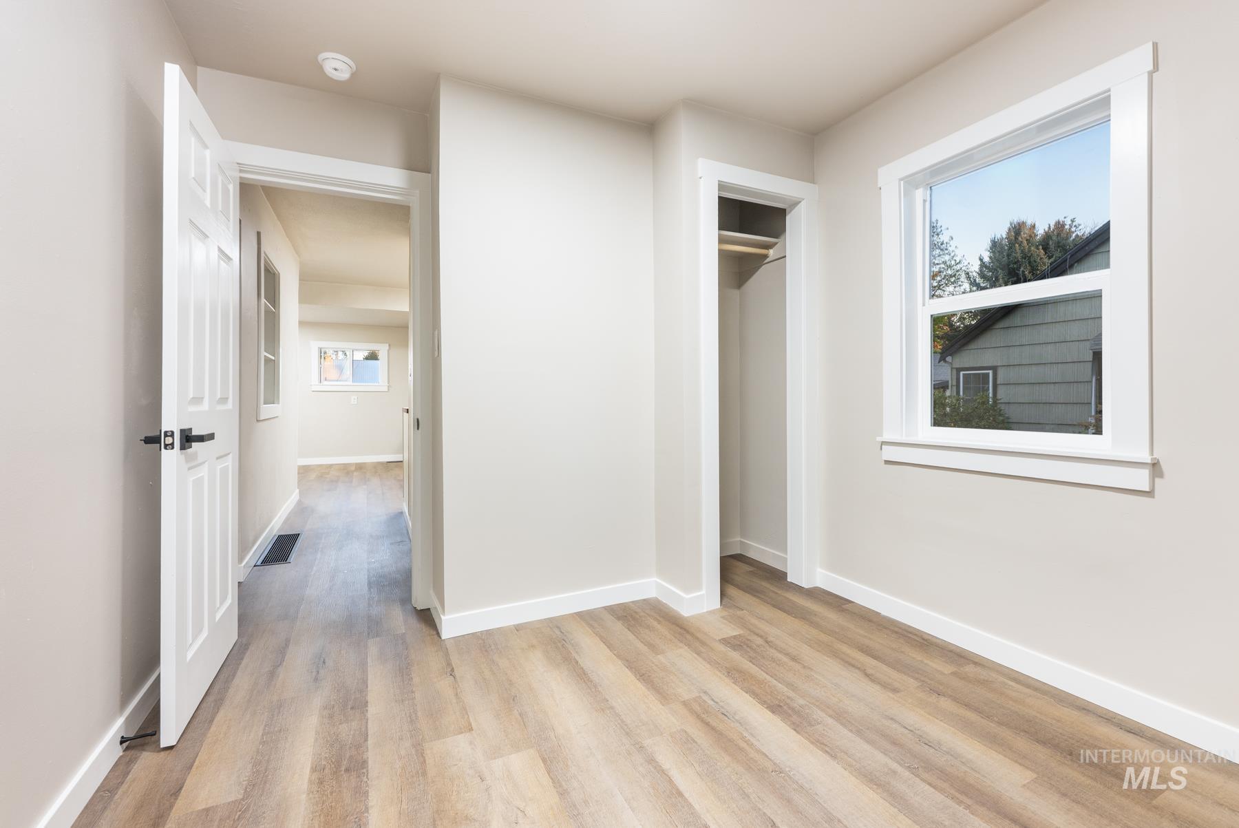 Unfurnished bedroom with light wood-type flooring and a closet