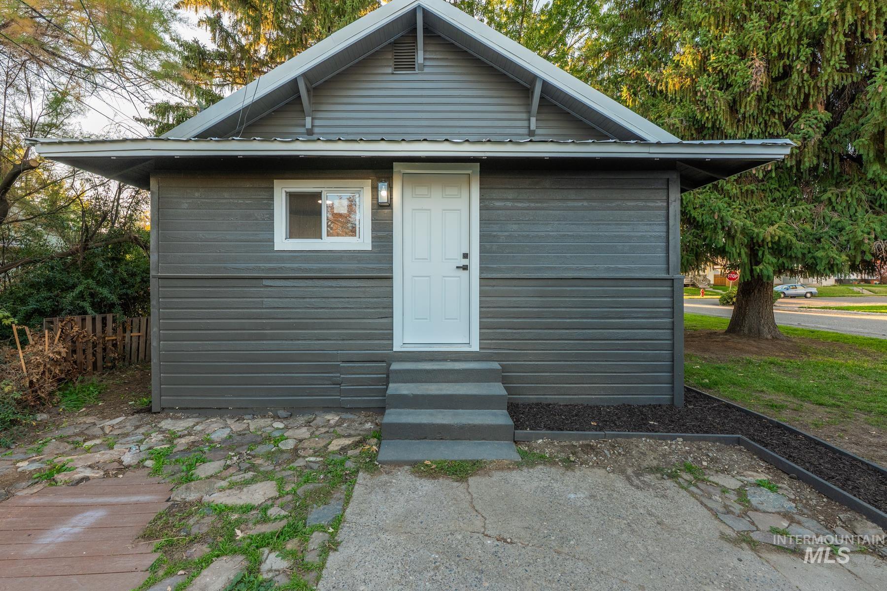 Back of property featuring entry steps and a metal roof