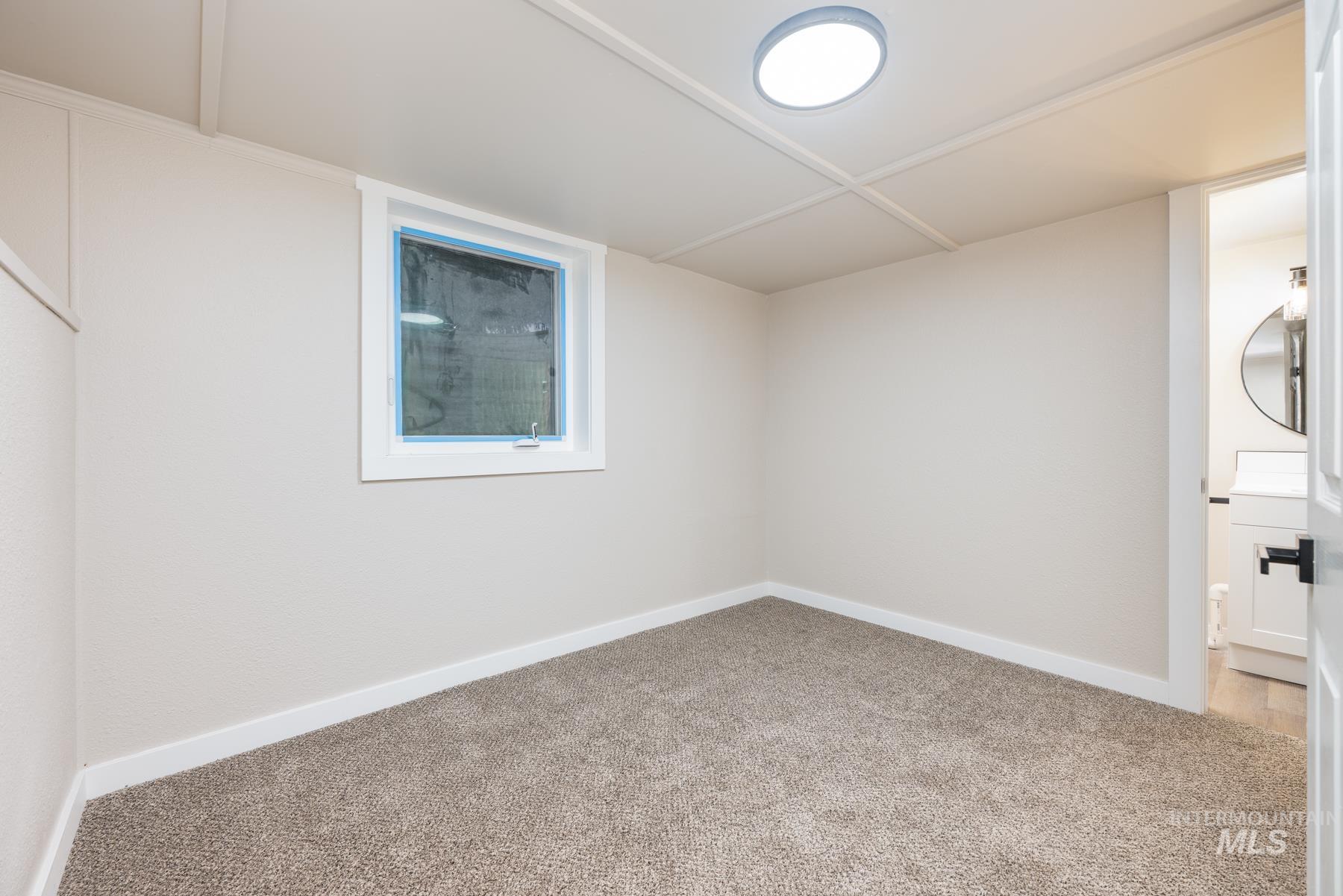 Unfurnished room with light colored carpet and baseboards