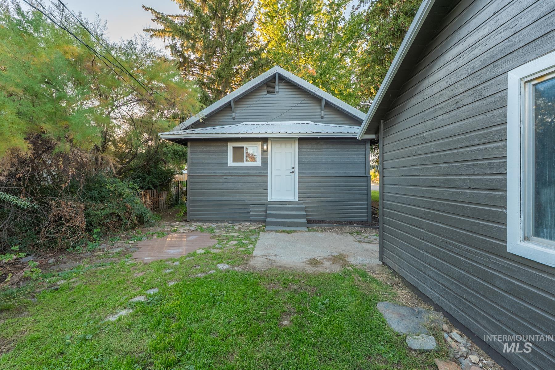 Back of property featuring a yard and entry steps