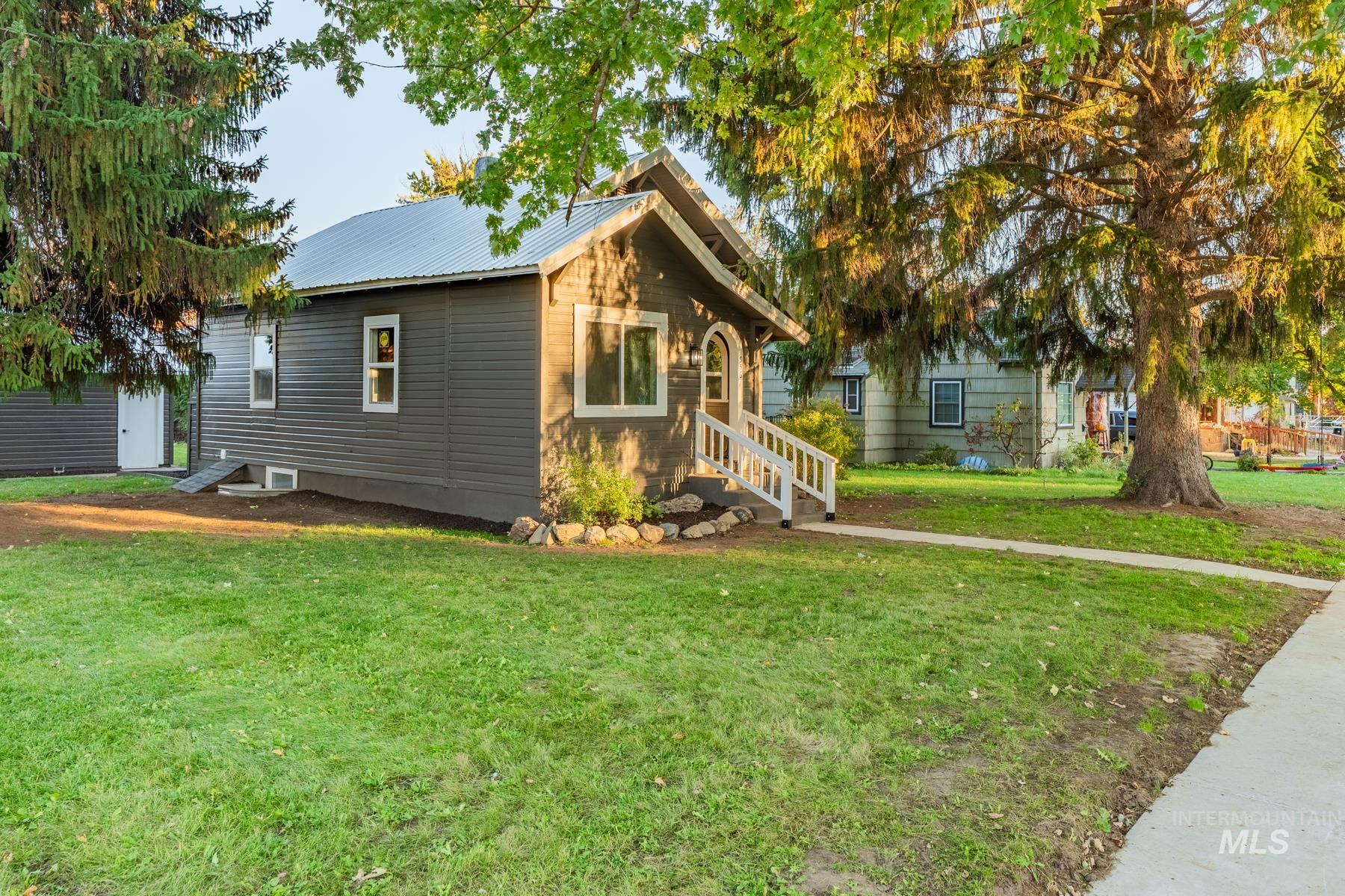 View of front of home featuring a front lawn and a metal roof