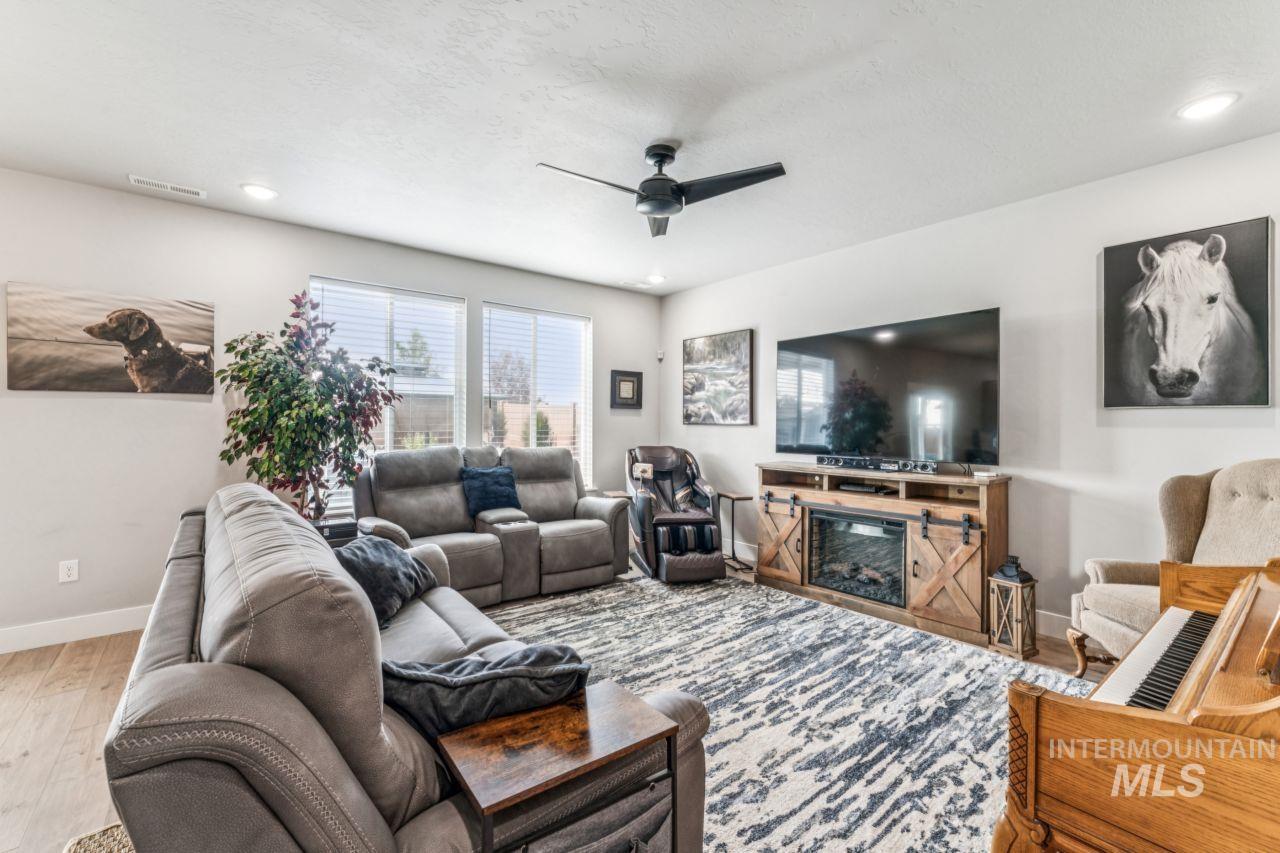 Living area featuring ceiling fan, wood finished floors, recessed lighting, and a textured ceiling