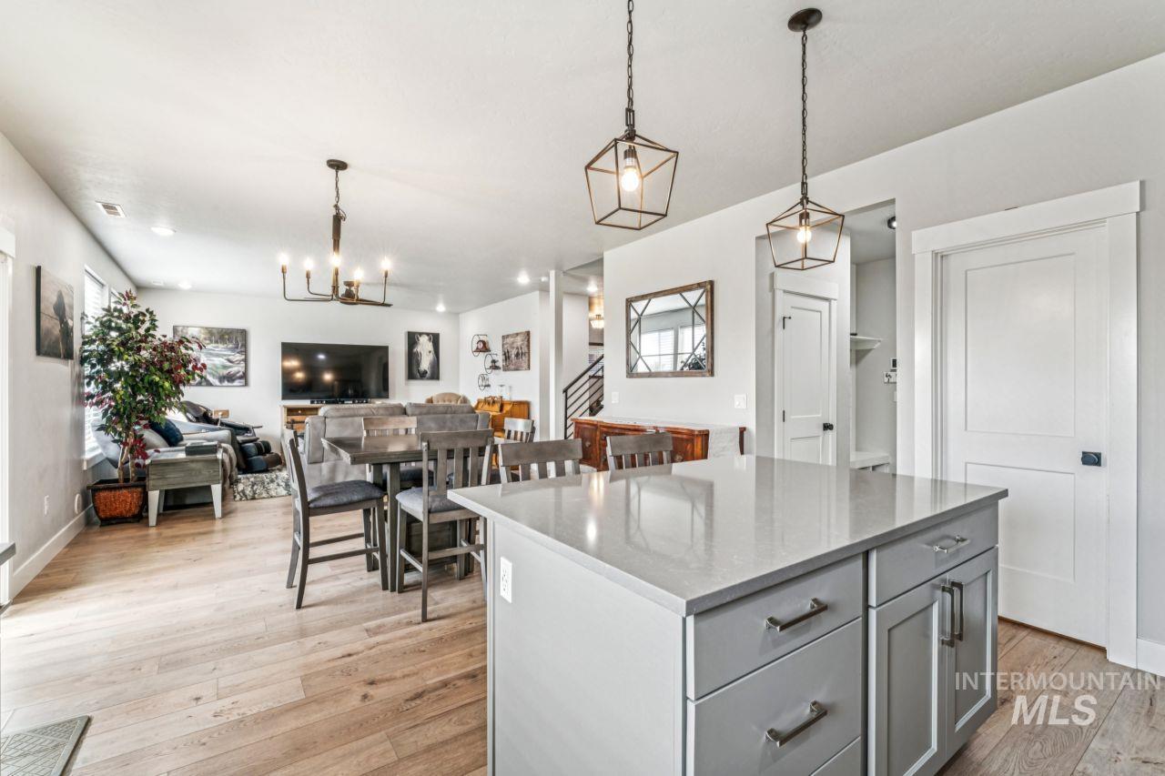 Kitchen featuring pendant lighting, a kitchen island, light wood-type flooring, and gray cabinetry