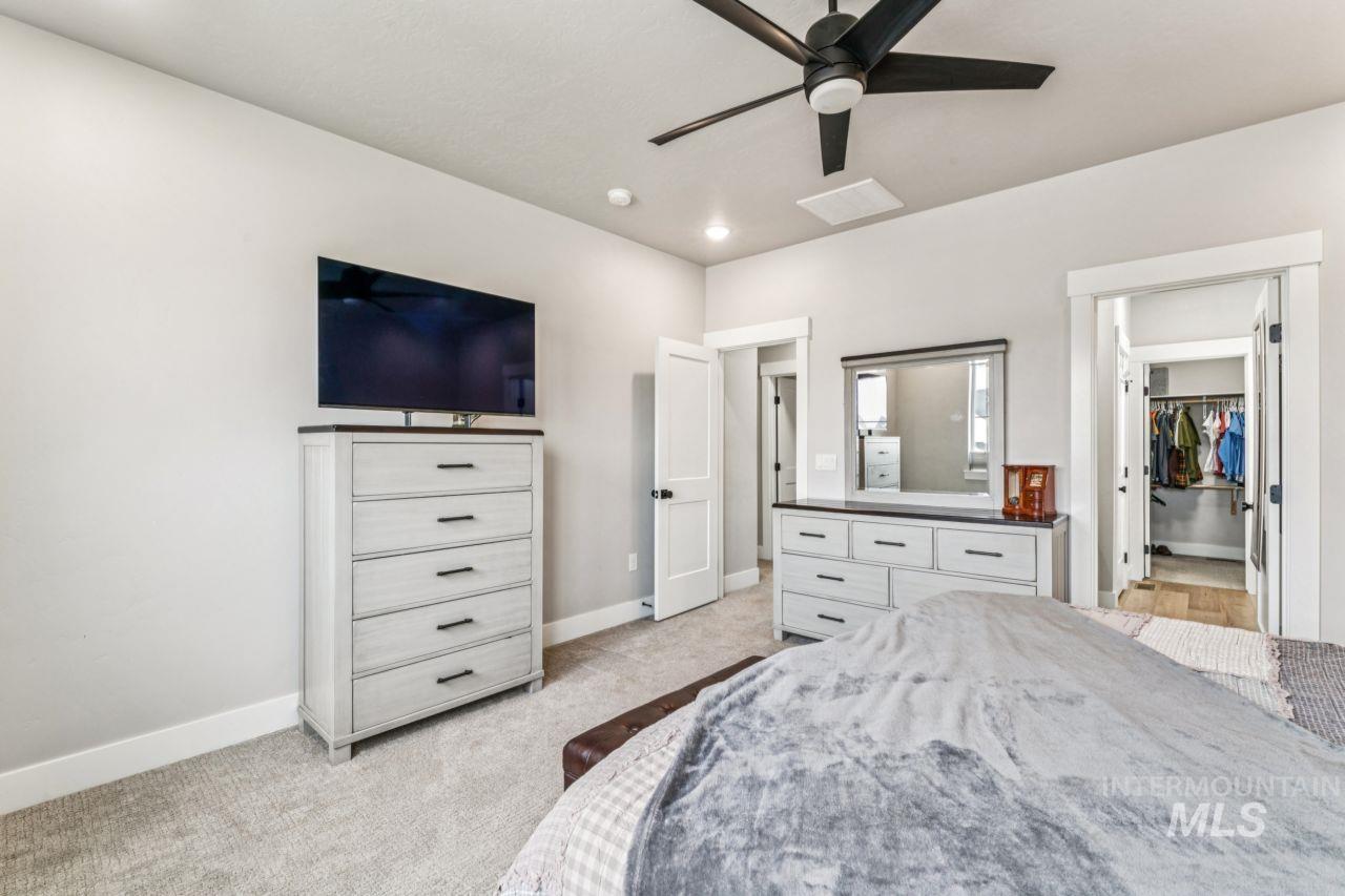 Bedroom with light carpet, ceiling fan, a spacious closet, and recessed lighting