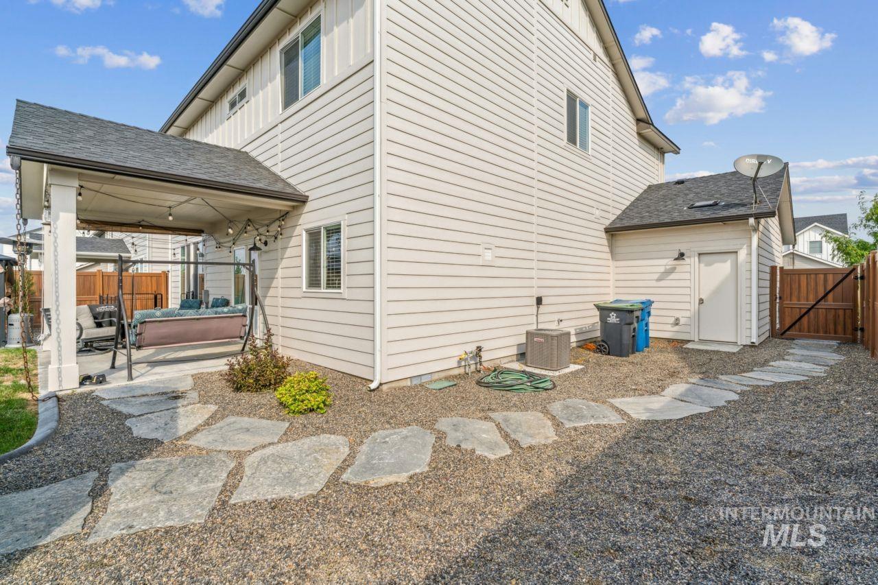 Back of house featuring a patio, a gate, and a shingled roof