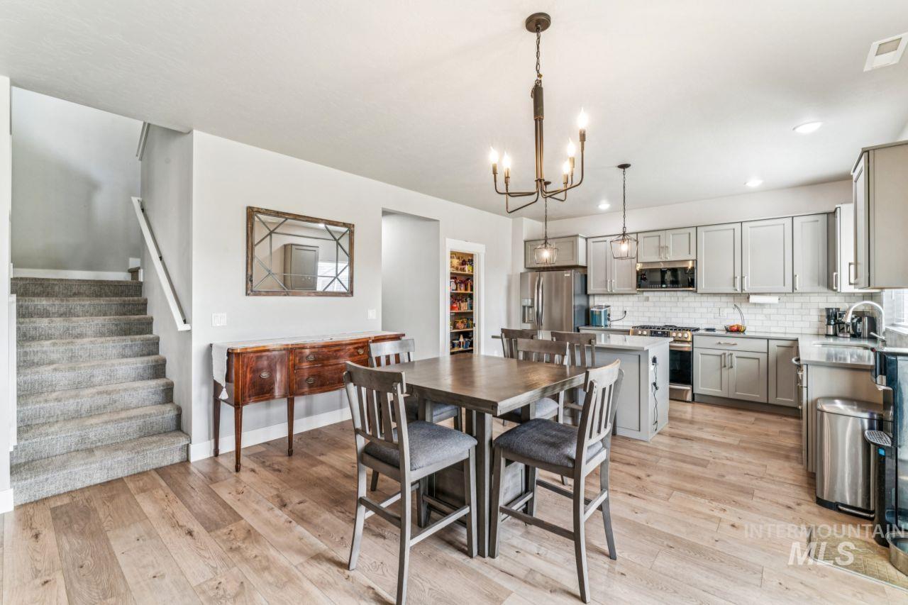 Dining space featuring light wood-style flooring, a chandelier, stairway, and recessed lighting