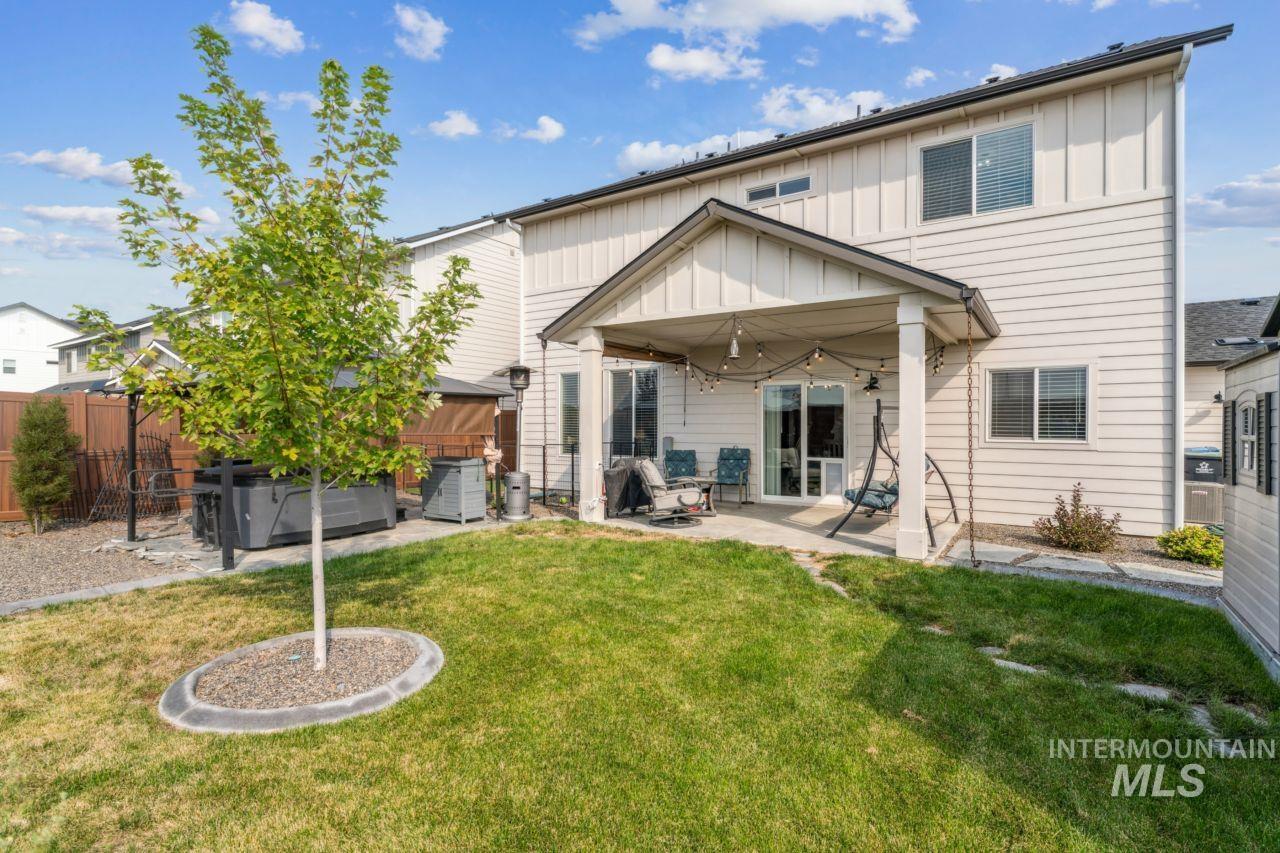 Back of property with a patio area, board and batten siding, and a fenced backyard