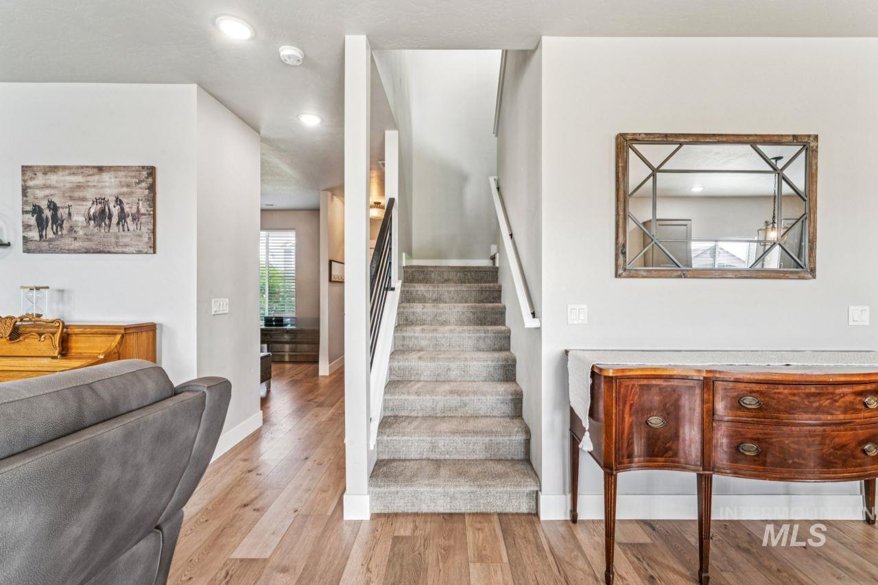 Staircase with wood finished floors and recessed lighting