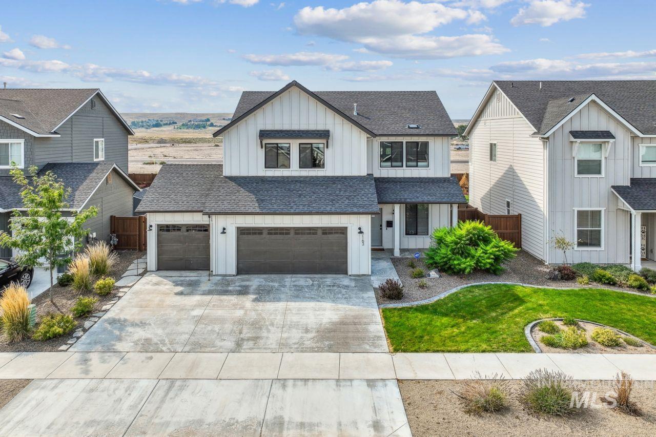 Modern farmhouse featuring board and batten siding, roof with shingles, concrete driveway, and a garage