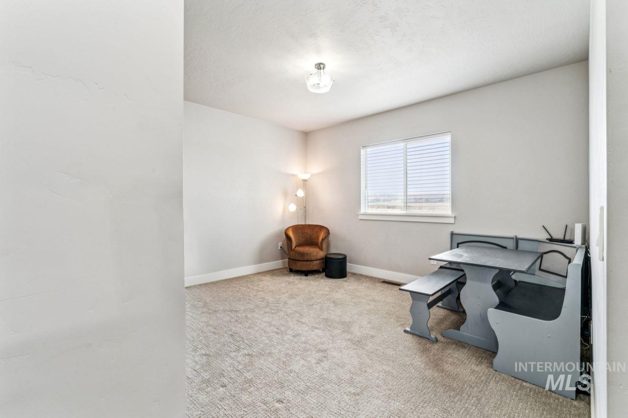 Office area featuring light colored carpet and baseboards
