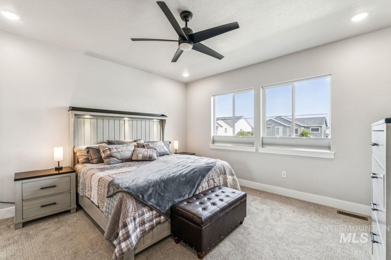 Bedroom with light carpet, ceiling fan, and recessed lighting