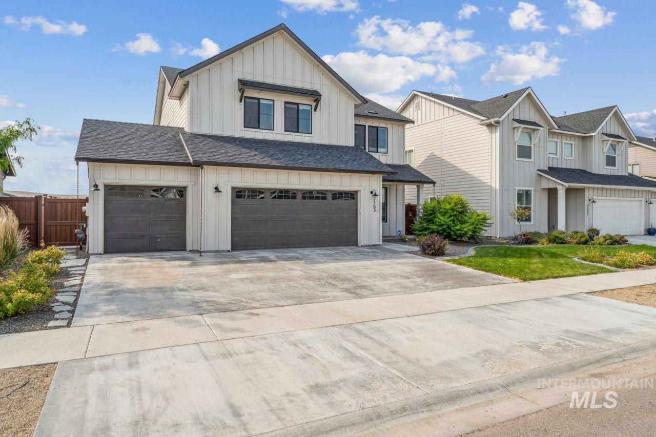 Modern farmhouse style home featuring board and batten siding, roof with shingles, driveway, and a garage