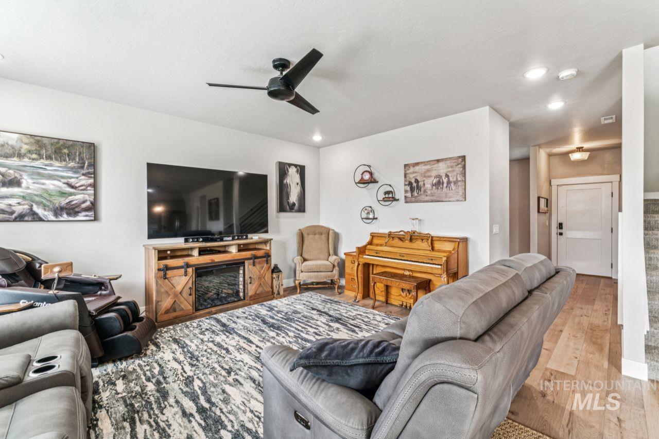 Living room featuring hardwood / wood-style floors, stairway, recessed lighting, and a ceiling fan