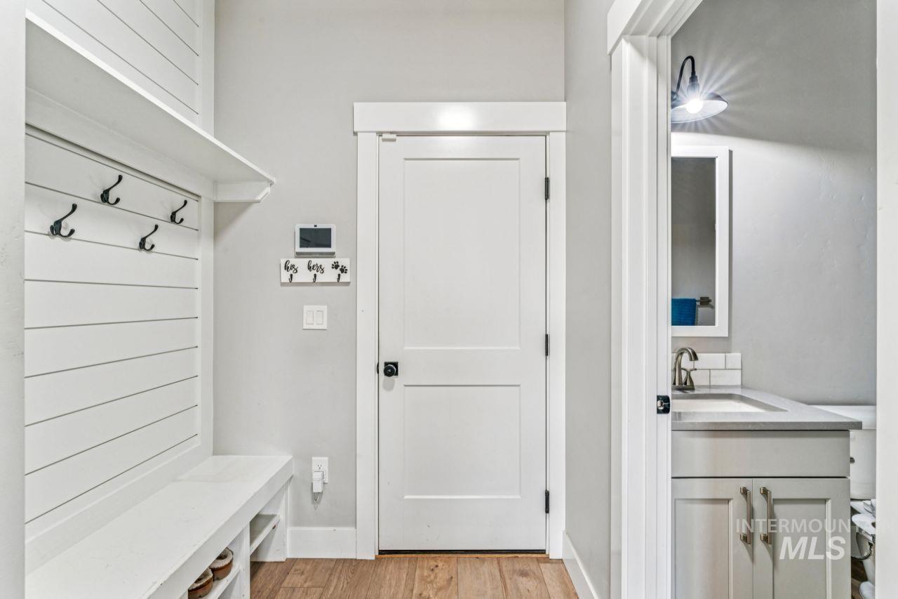 Mudroom with light wood-type flooring and baseboards