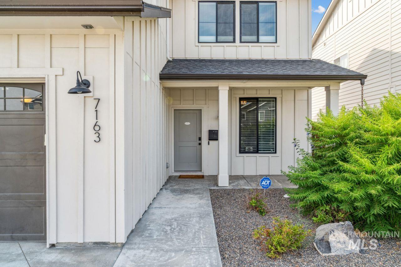 Entrance to property with board and batten siding and a shingled roof