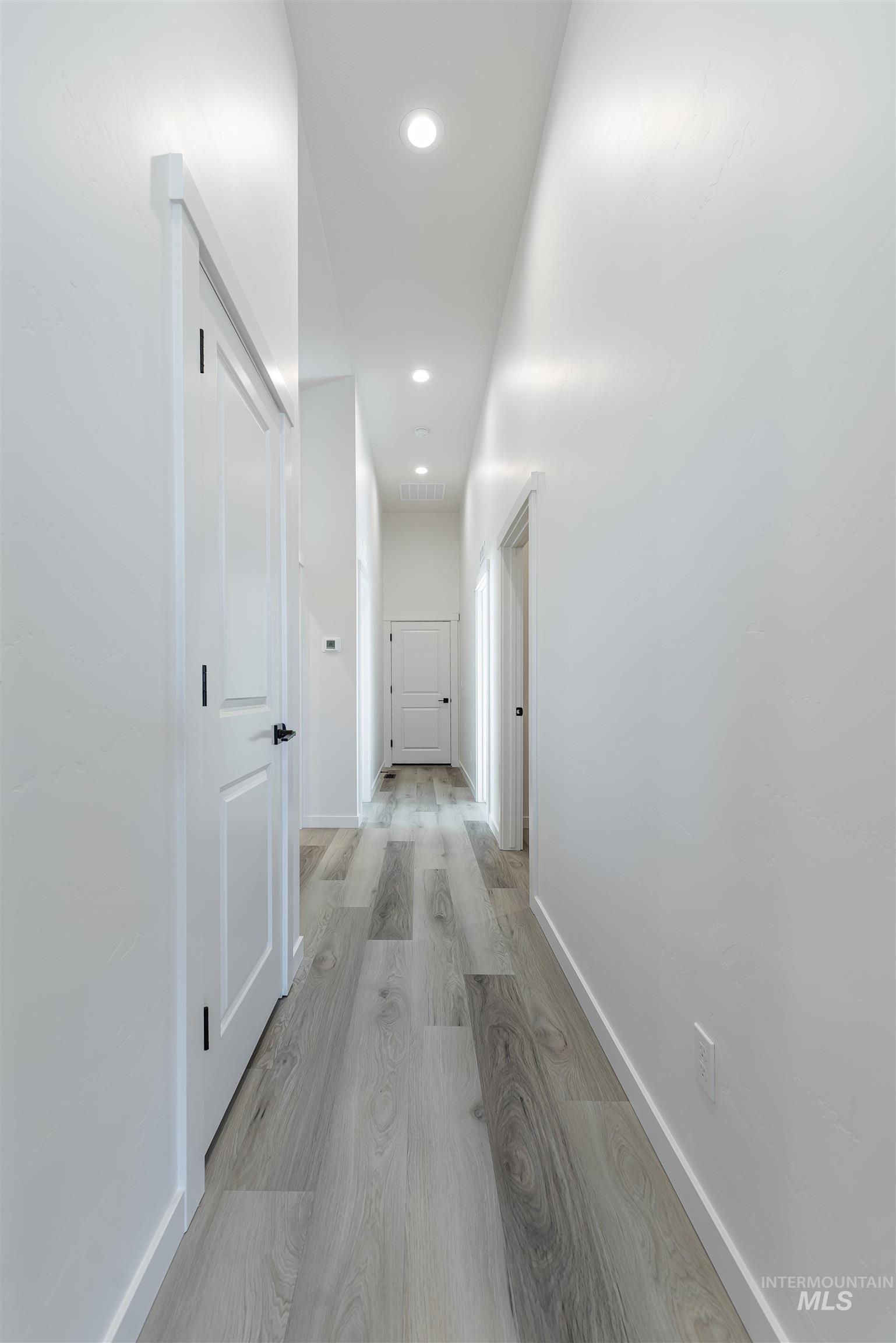 Corridor featuring light wood-type flooring and recessed lighting