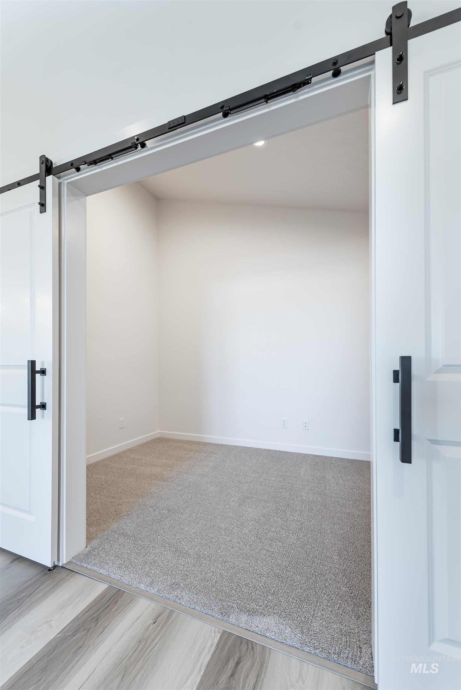 Spare room featuring a barn door and light wood-style floors