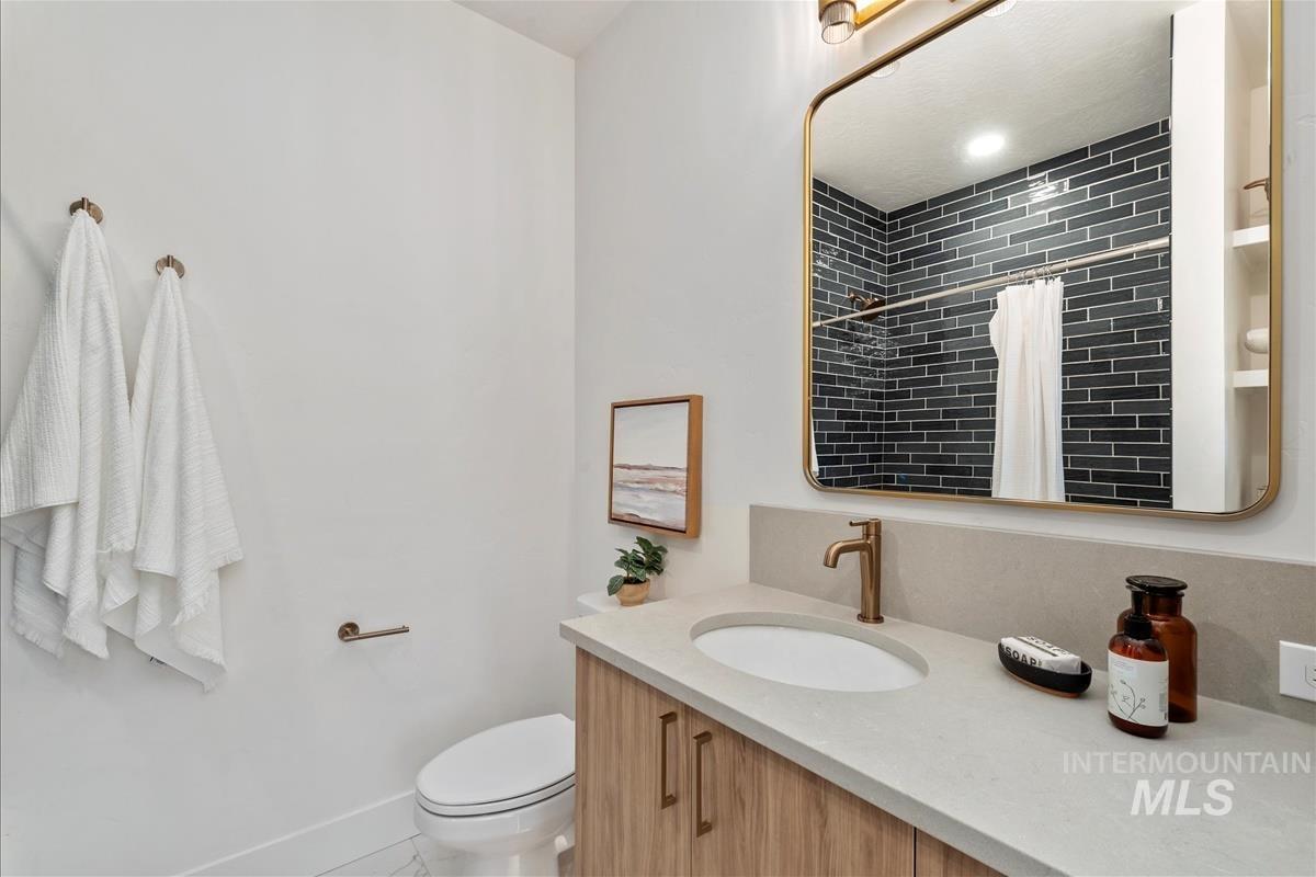 Bathroom with curtained shower, vanity, and light tile patterned floors