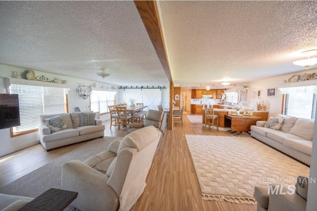 Living room featuring light wood-type flooring and a textured ceiling