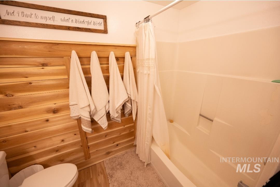 Bathroom featuring shower / bath combo with shower curtain and light wood finished floors