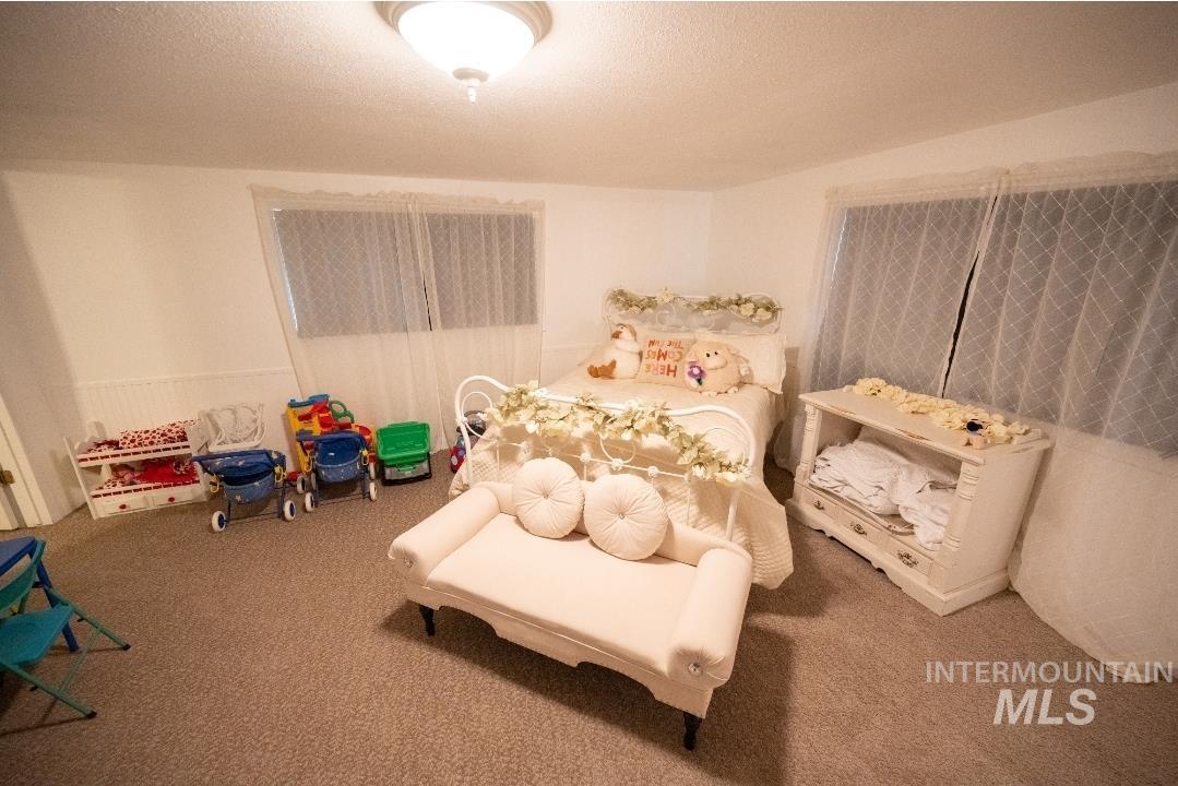Bedroom with a textured ceiling and carpet floors