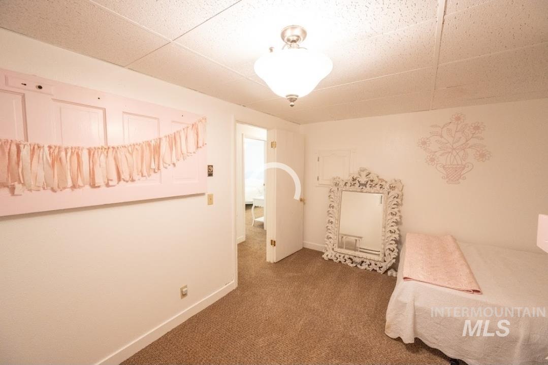 Bedroom with carpet flooring and a paneled ceiling