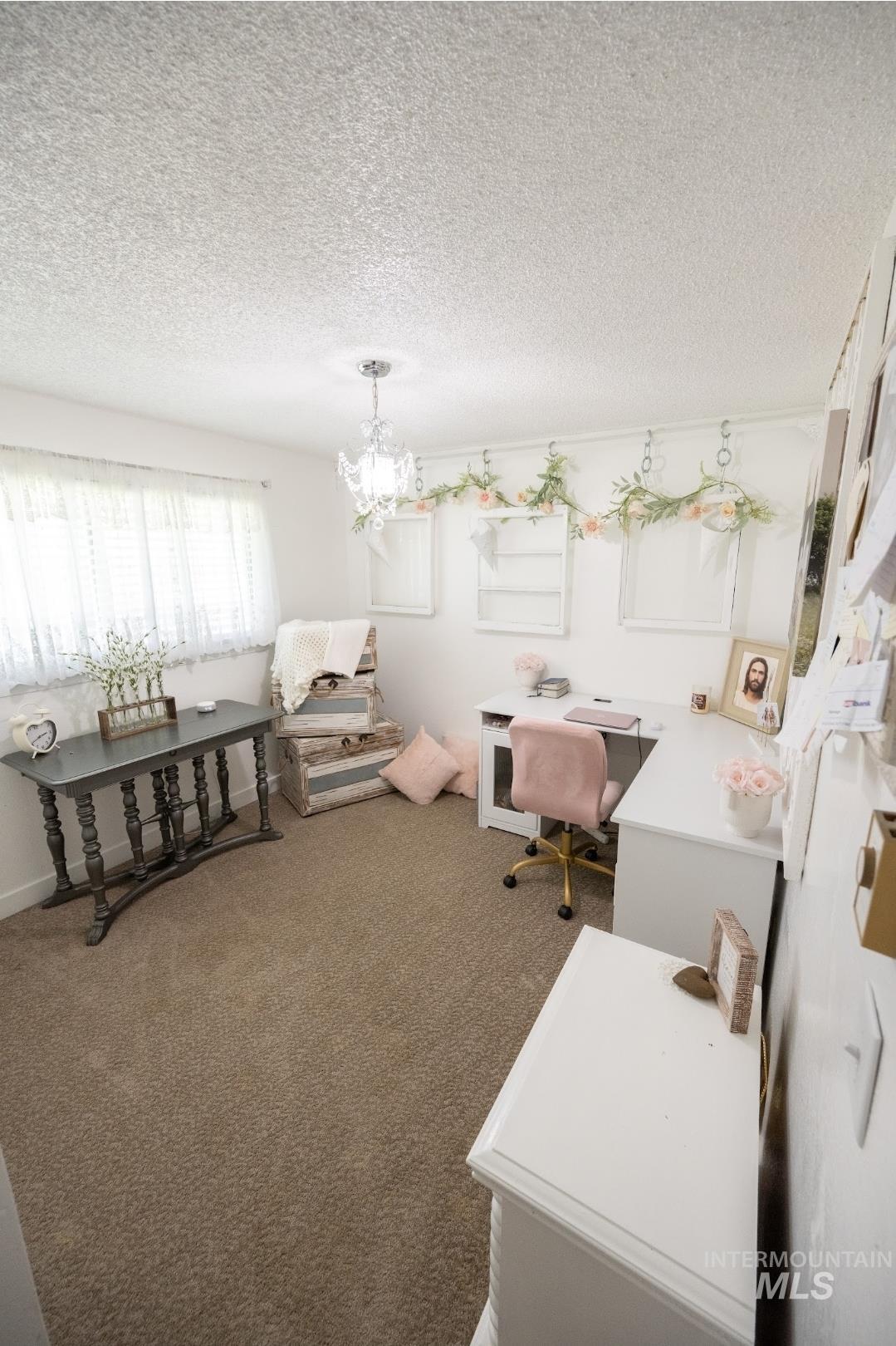 Office featuring a textured ceiling, carpet floors, and a chandelier