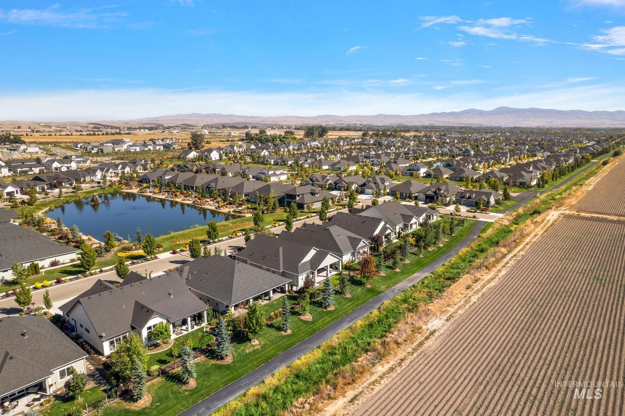 Aerial view of property and surrounding area featuring a mountain backdrop and nearby suburban area