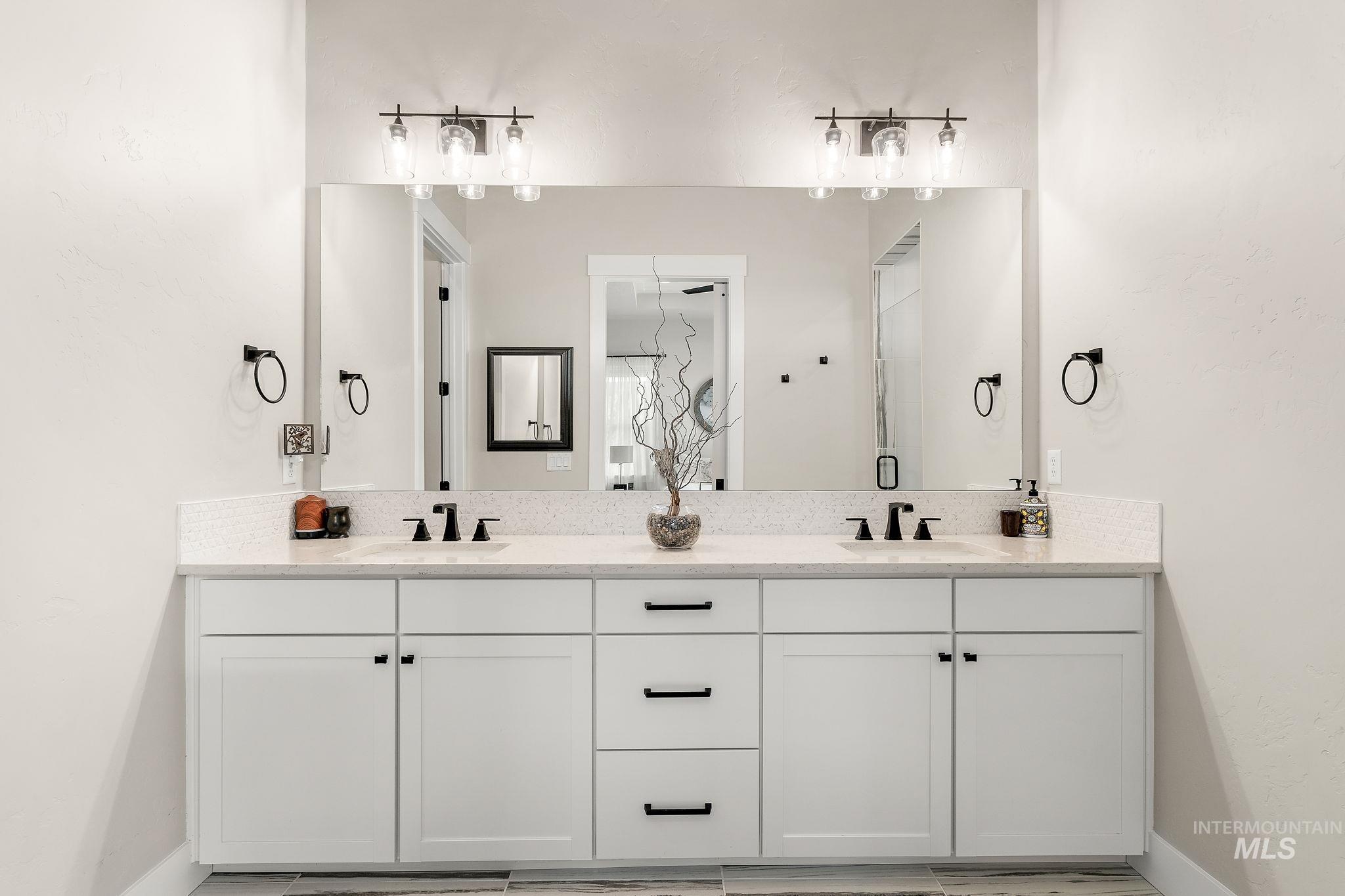 Full bath with double vanity and baseboards