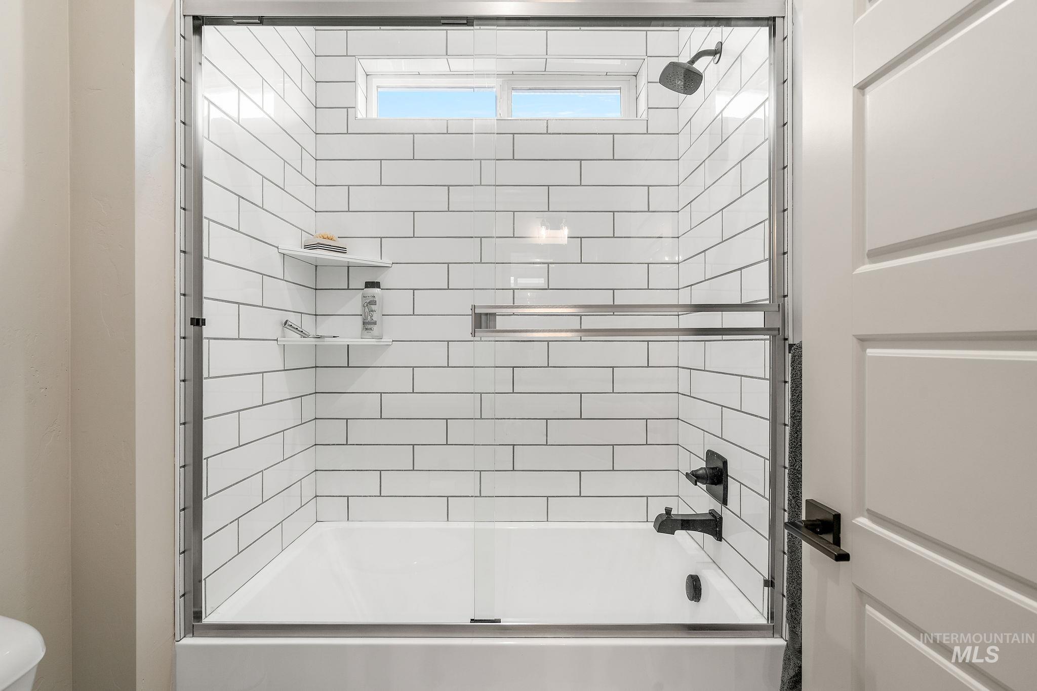 Full bathroom featuring enclosed tub / shower combo and toilet