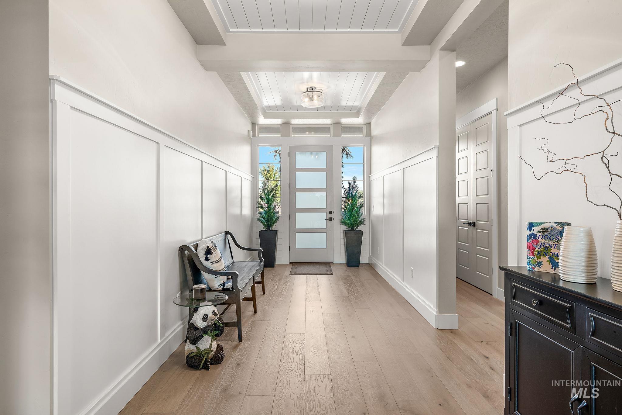 Foyer entrance featuring light wood finished floors and a decorative wall