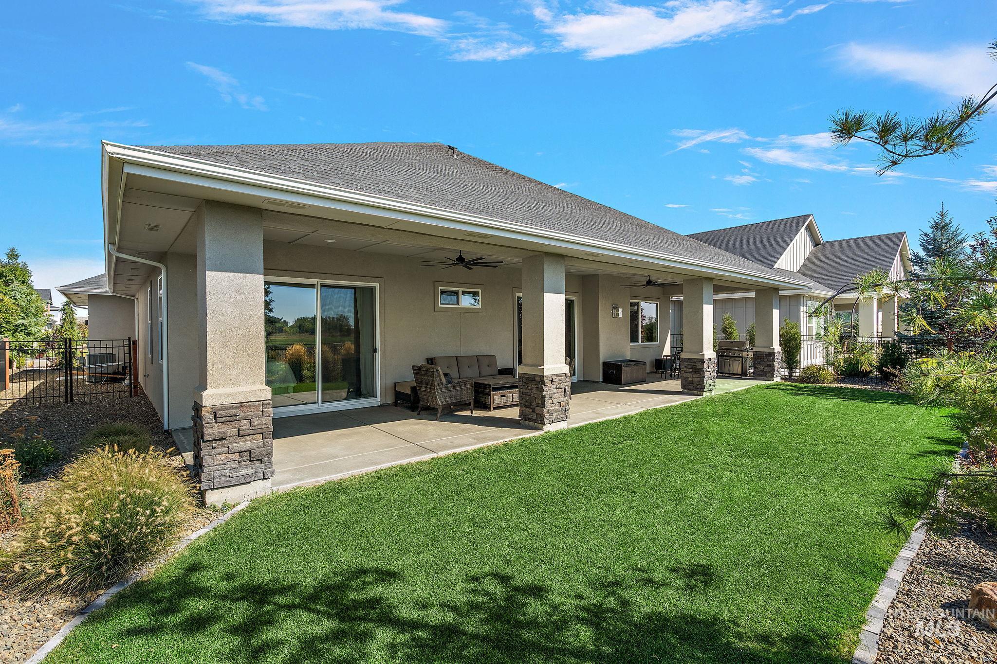 Rear view of property featuring a patio area, stucco siding, a ceiling fan, roof with shingles, and outdoor lounge area