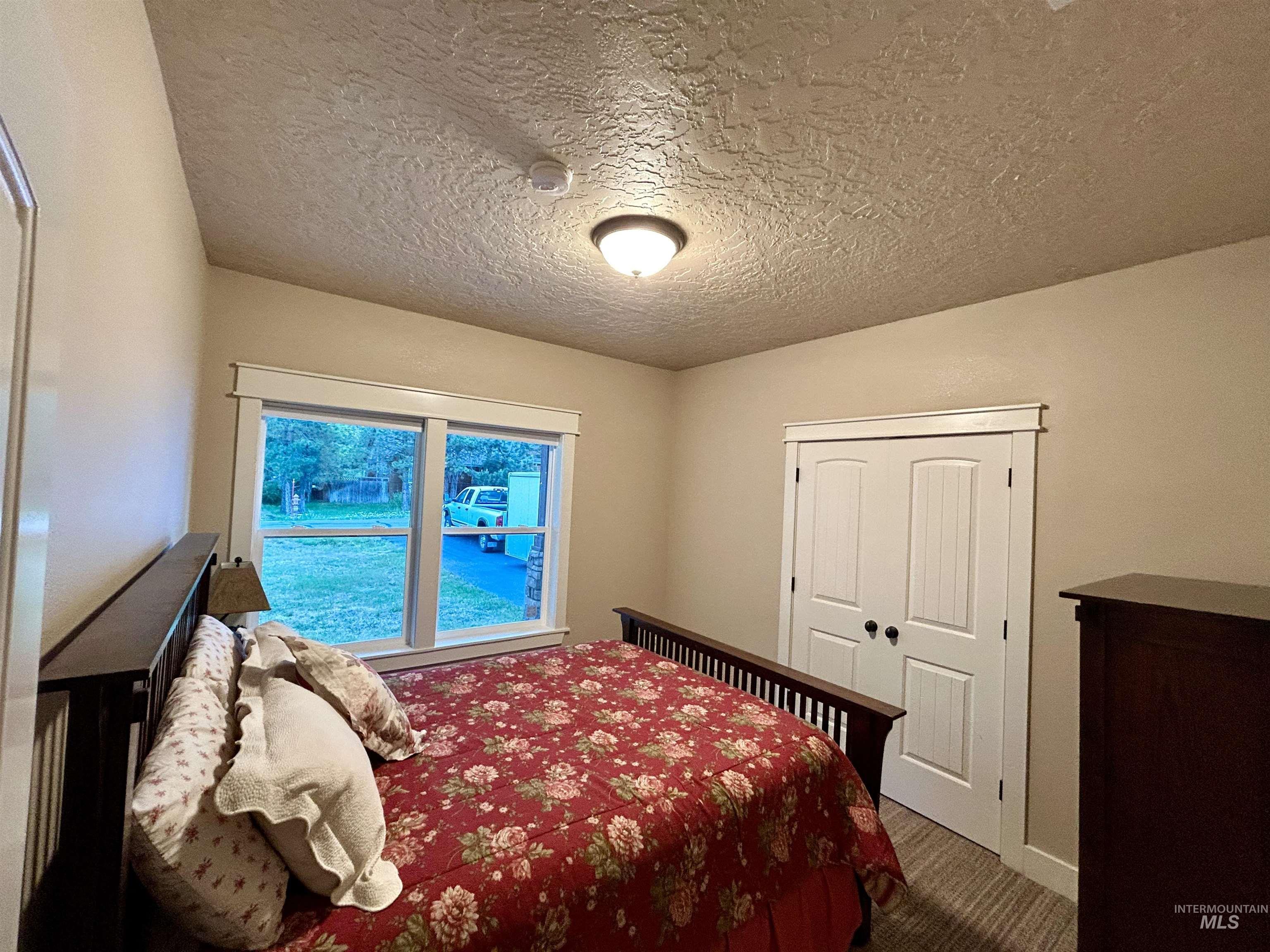 Carpeted bedroom featuring a textured ceiling