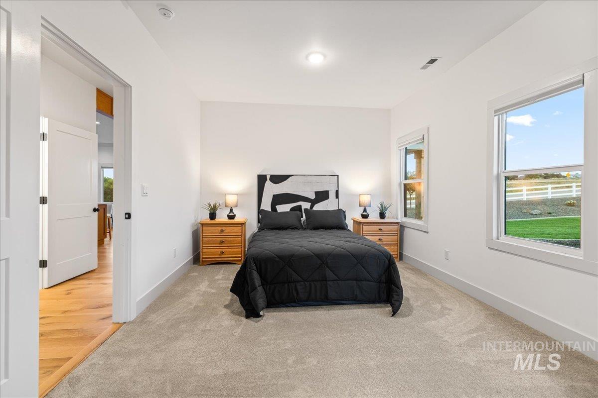 Bedroom with carpet floors and multiple windows