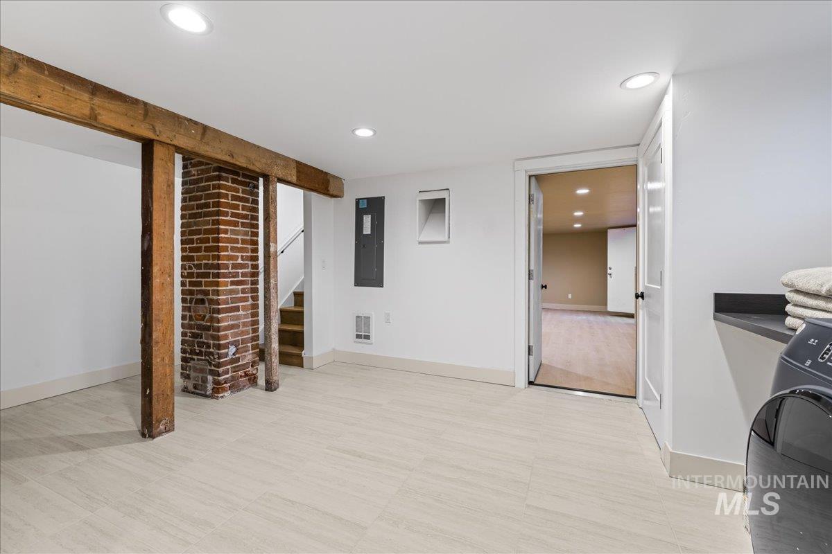 Finished basement with washer / clothes dryer, recessed lighting, electric panel, and stairs