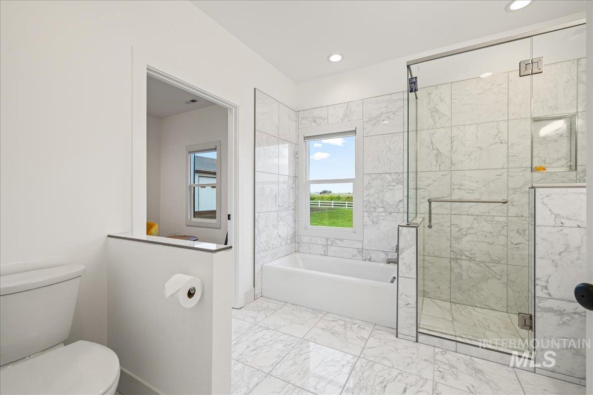 Full bathroom with a bath, a stall shower, light marble finish flooring, and recessed lighting