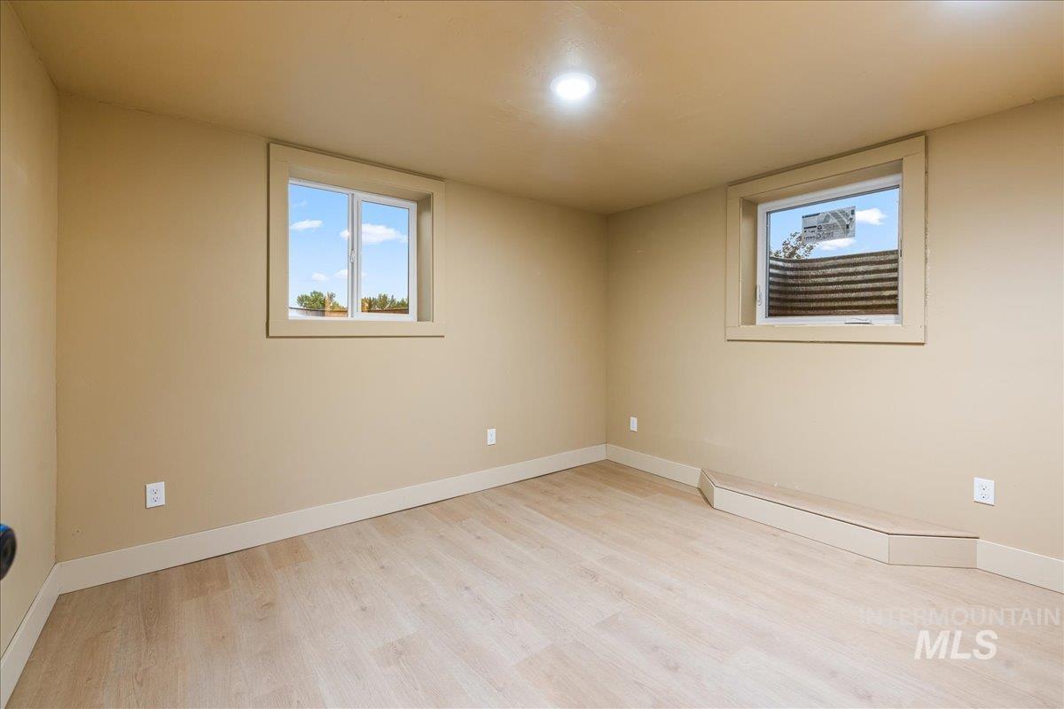 Below grade area featuring baseboards and light wood finished floors
