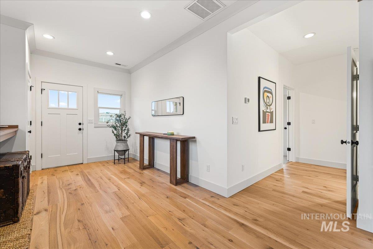 Entrance foyer featuring light wood-style flooring, recessed lighting, and crown molding