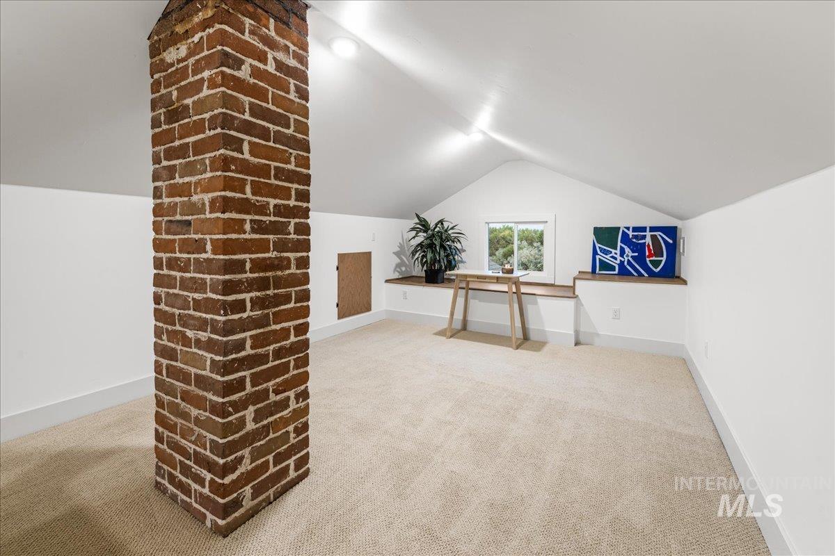 Additional living space with light colored carpet and lofted ceiling