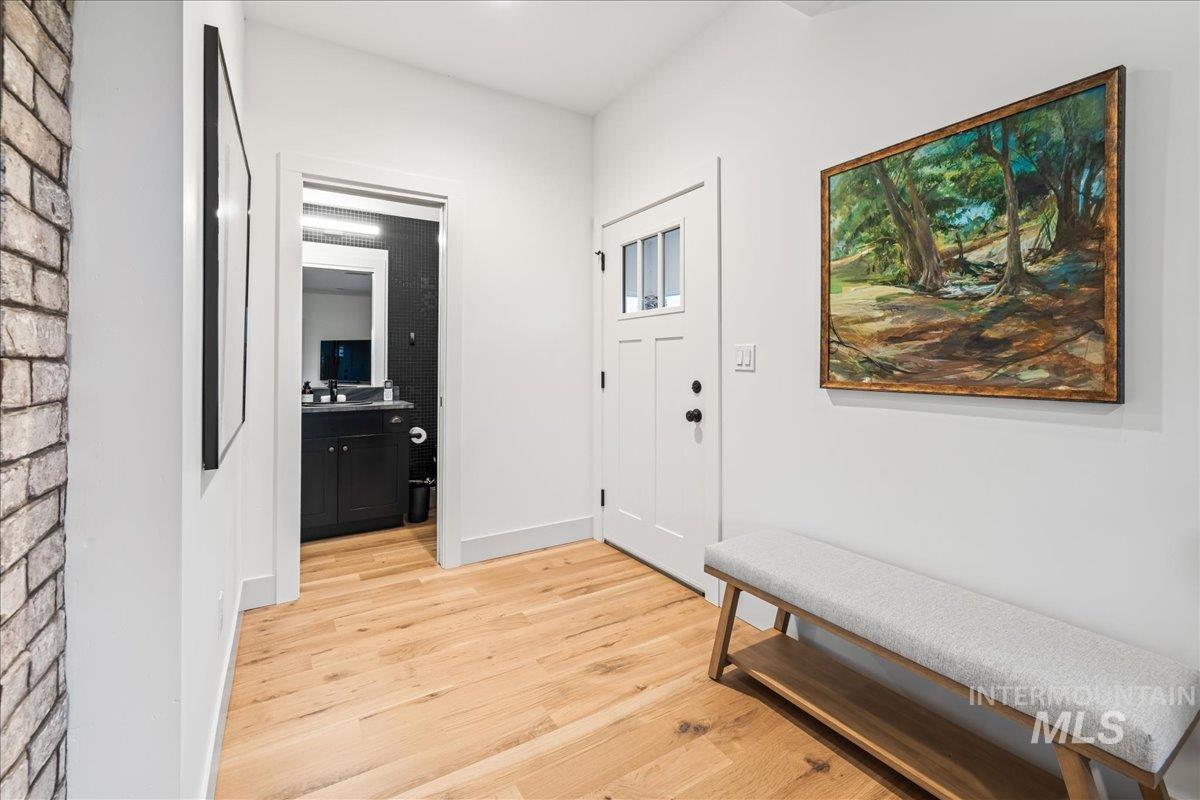 Foyer entrance with light wood-type flooring and baseboards
