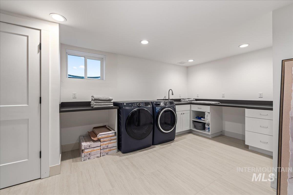 Washroom with recessed lighting, washing machine and clothes dryer, and cabinet space