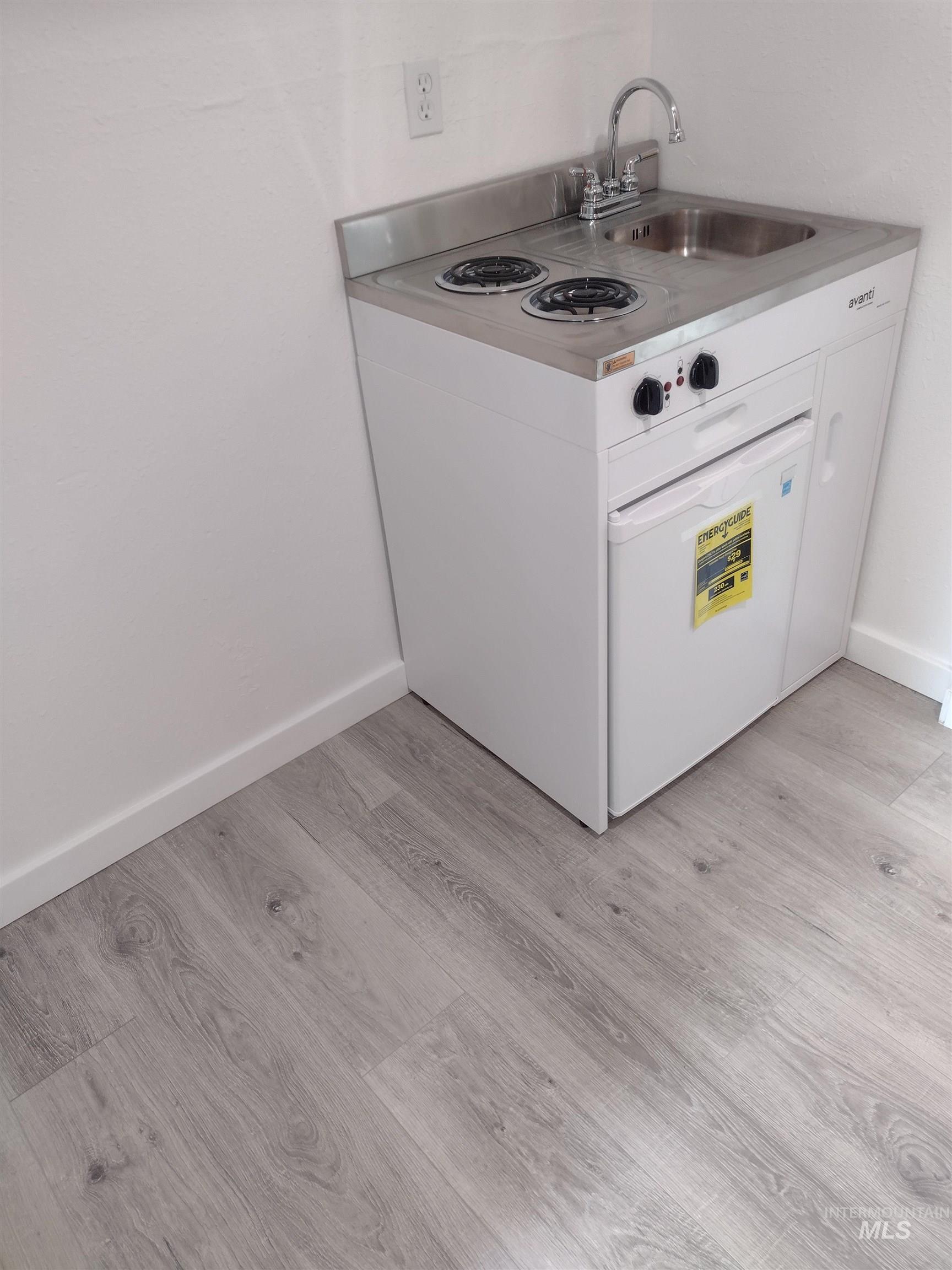 Kitchen with white cabinets, light wood-style floors, white range oven, and light countertops