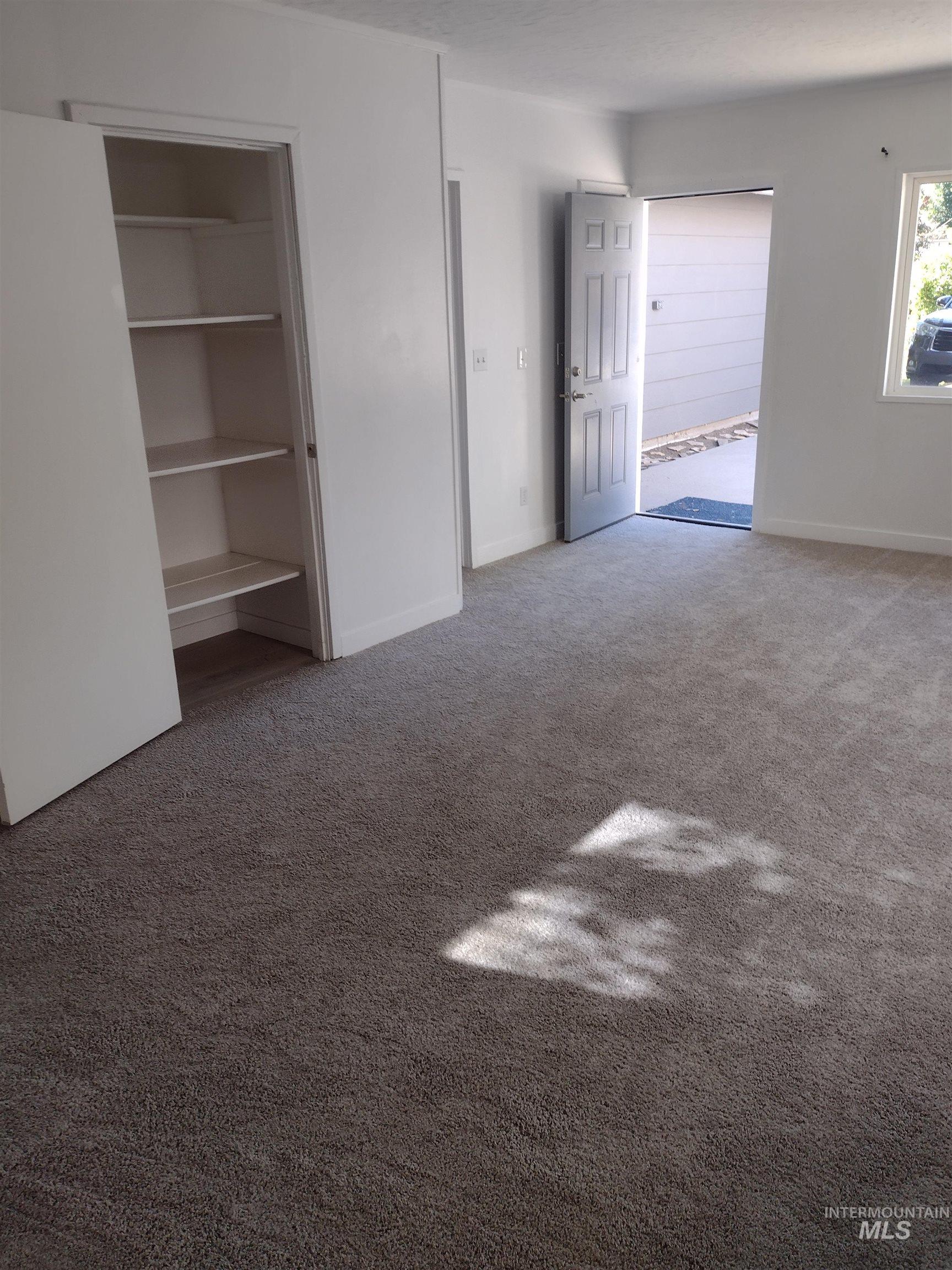 Unfurnished bedroom featuring light colored carpet and baseboards