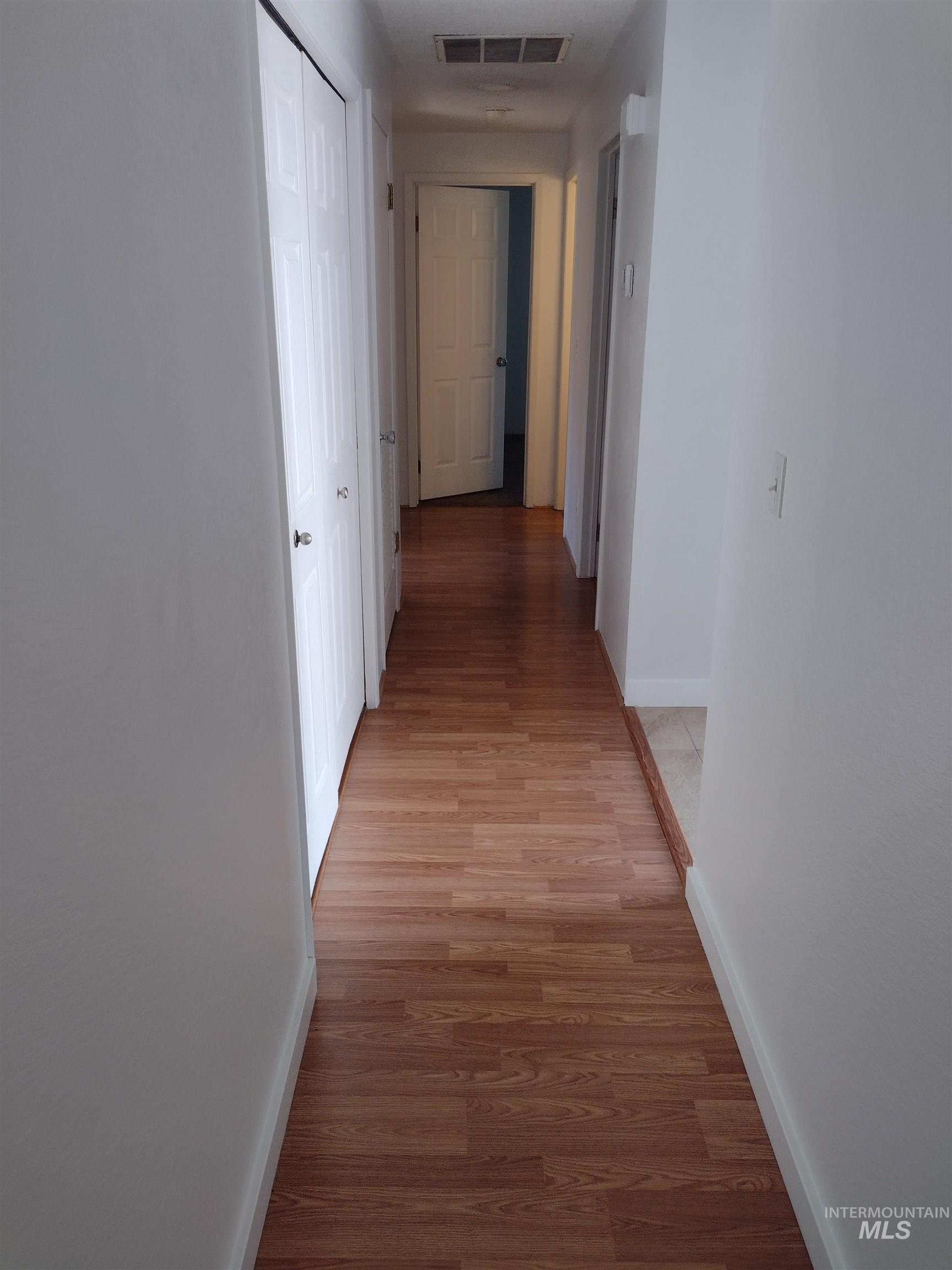 Corridor featuring baseboards and light wood-style floors