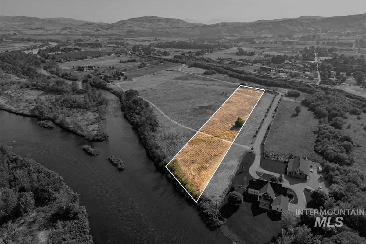 Aerial view of sparsely populated area with property boundaries highlighted and a water and mountain view