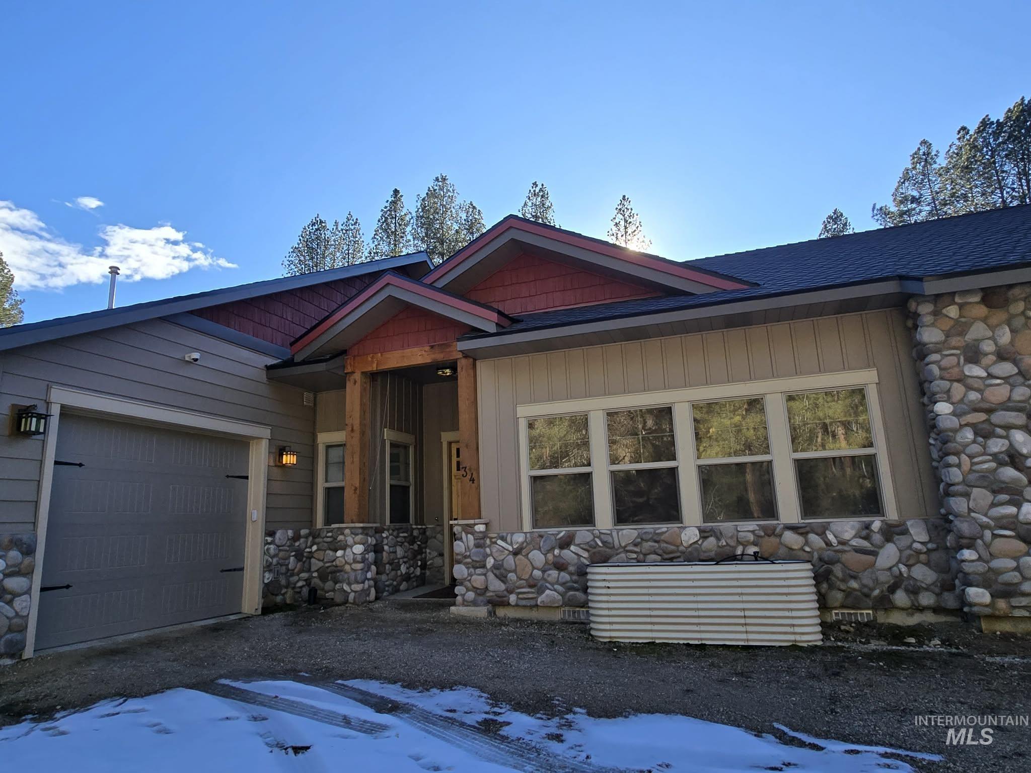 View of front of property featuring stone siding and an attached garage