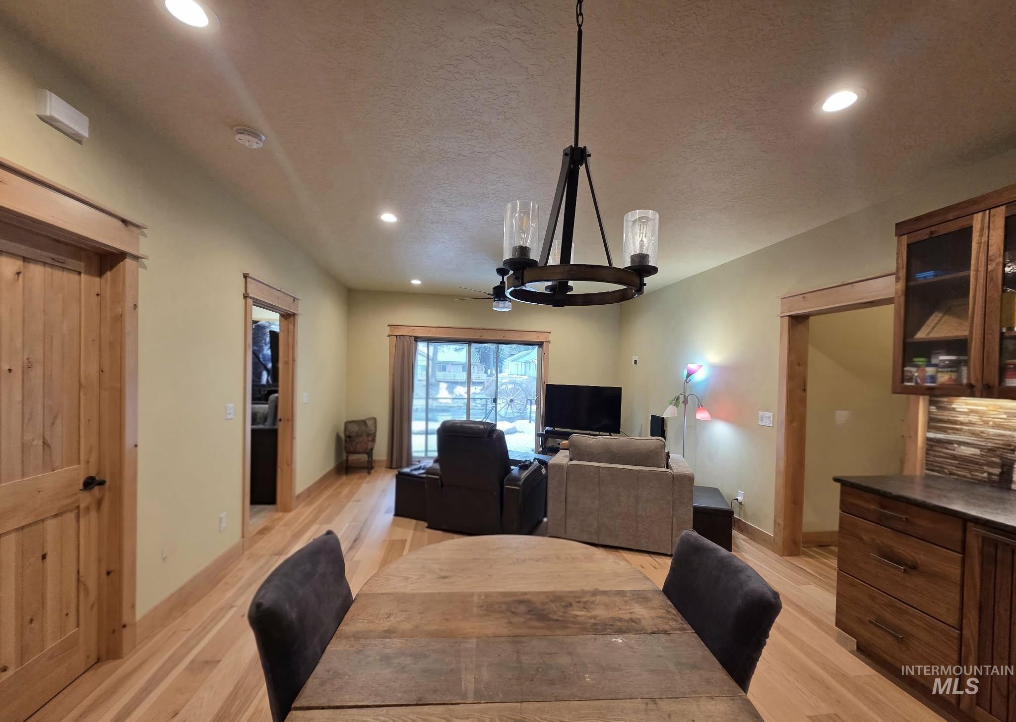 Apartment Dining area with recessed lighting, light wood-style floors, a textured ceiling, and a chandelier