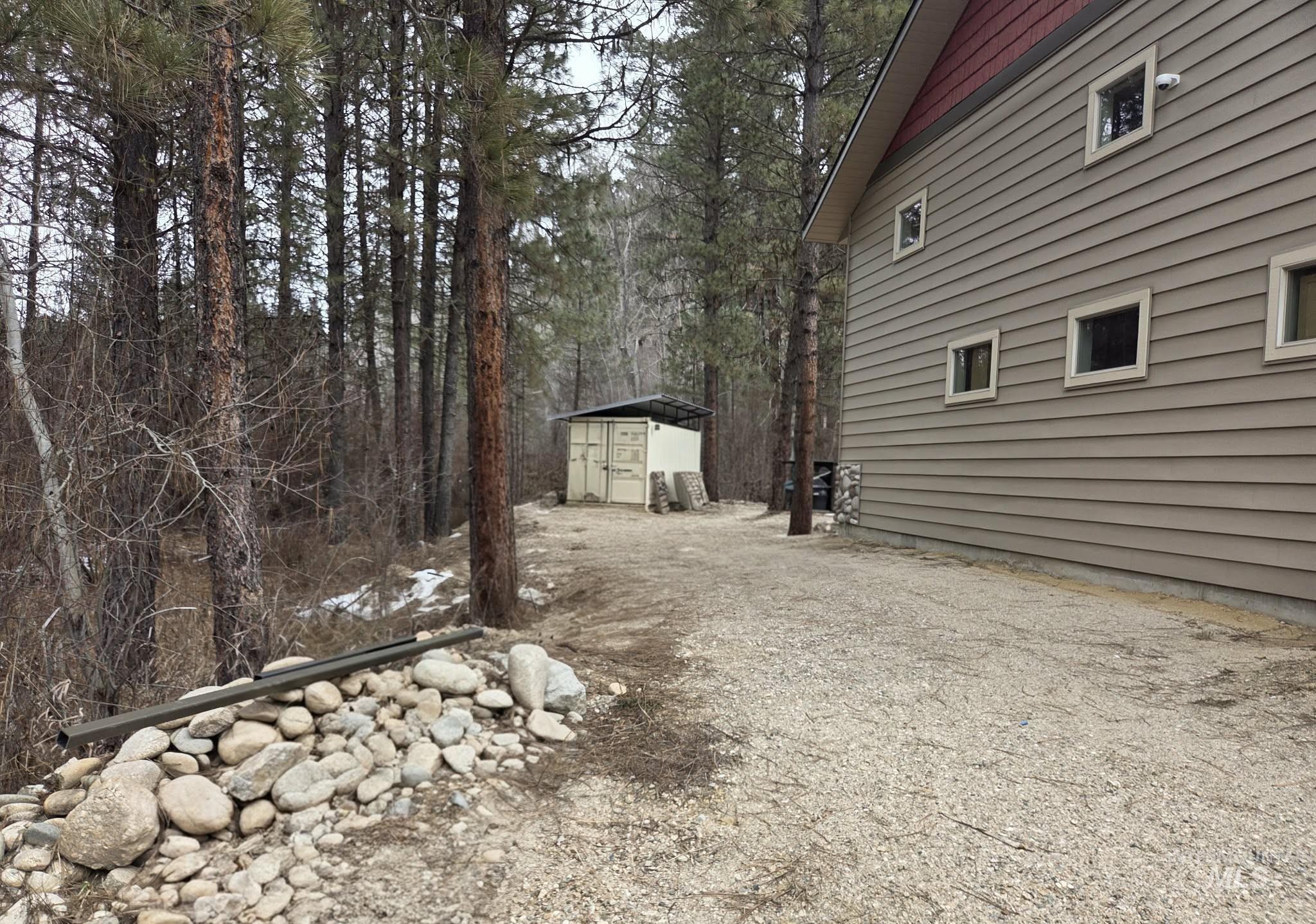 View of home's exterior with a shed and dirt driveway