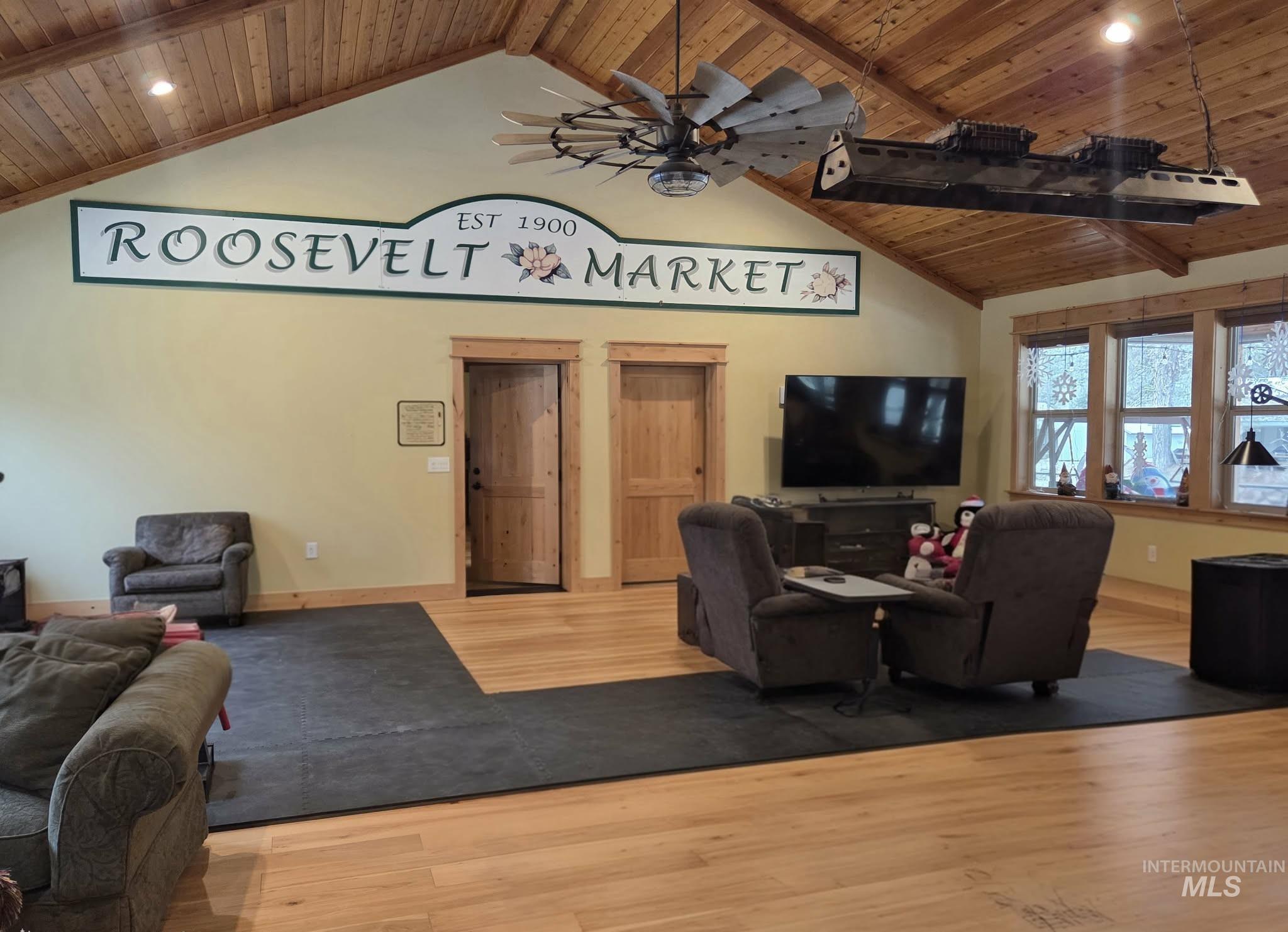 Living area featuring a wooden ceiling with exposed beams, wood finished floors, recessed lighting, ceiling fan, and high vaulted ceiling