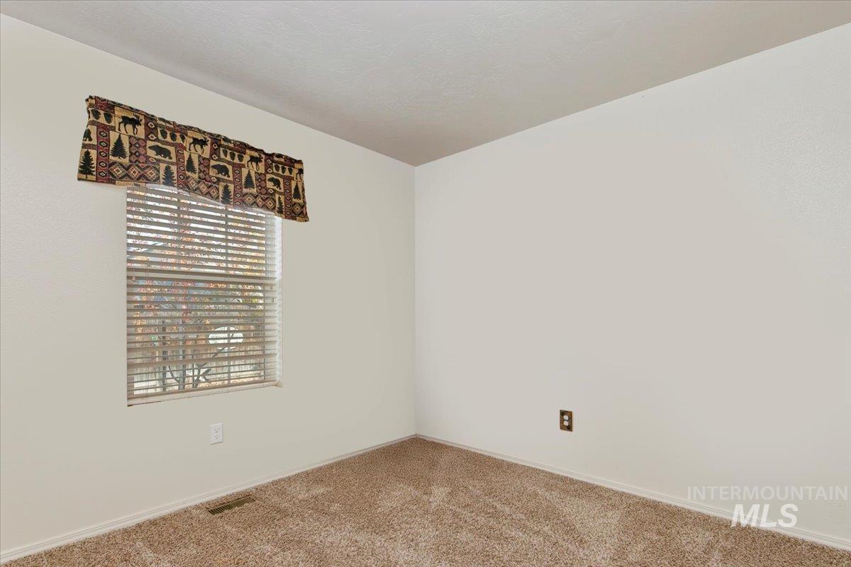 Carpeted empty room featuring baseboards